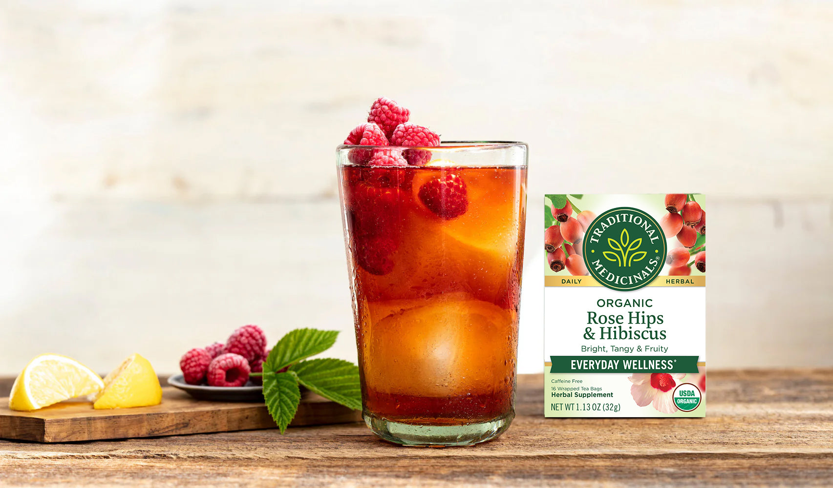 Sweet tea in a glass cup and Rose Hips & Hibiscus Tea box on a table
