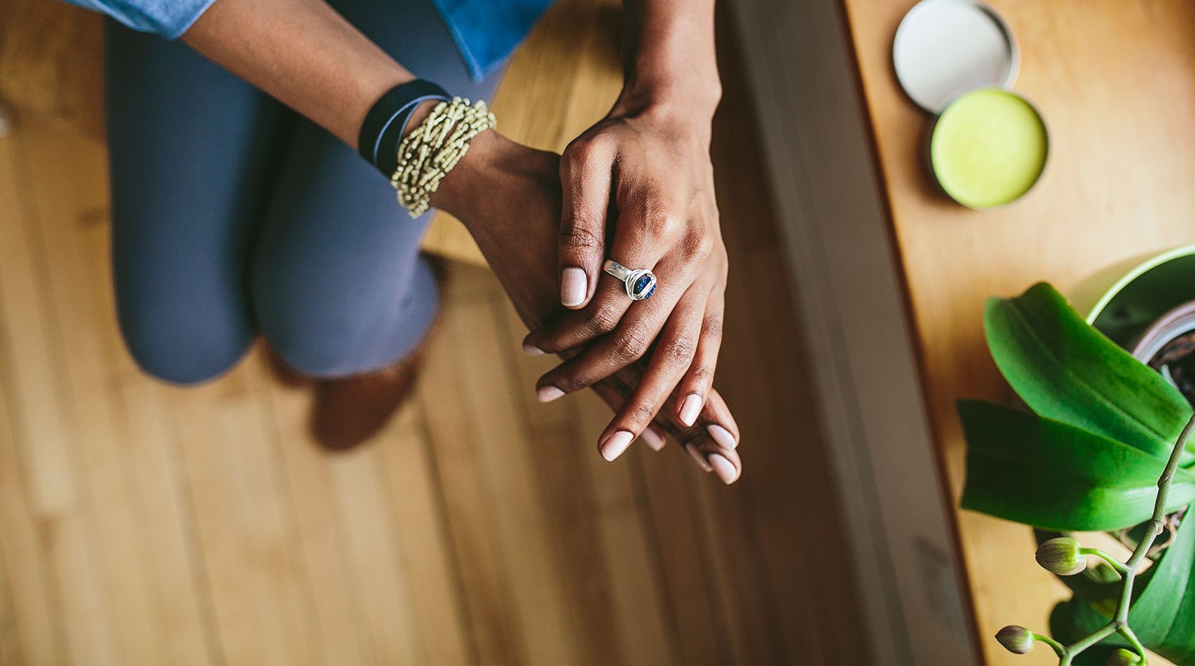woman rubbing salve on hands overhead view